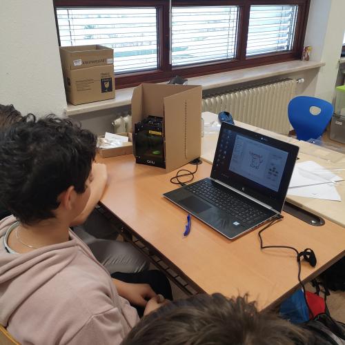 Schüler mit Laptop und Lasercutter