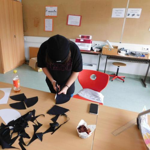 Schülerin beim Zuschneiden des Stoffes für selbstgenähte Masken