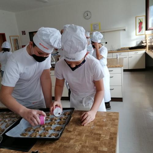 Schülerinnen und Schüler beim Kekse backen