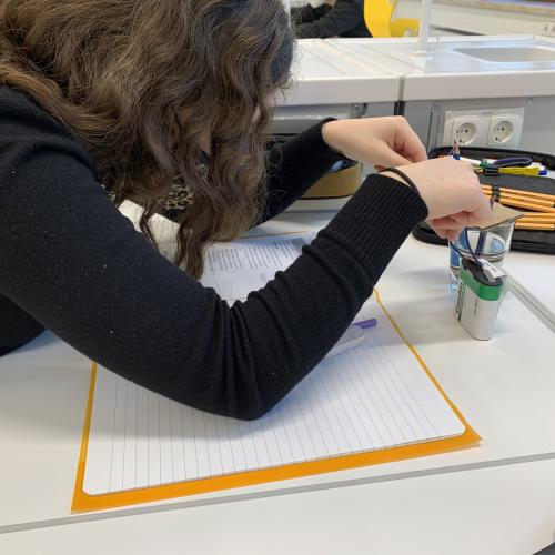 Schülerin beim Experimentieren mit einer Batterie