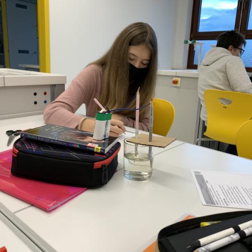 Schülerin beim Protokollieren eines Experiments