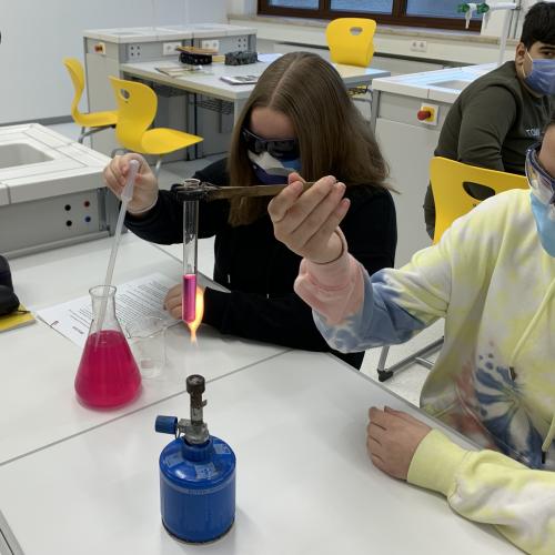 Schülerinnen beim Experimentieren mit Bunsenbrenner und Erlemayerkolben