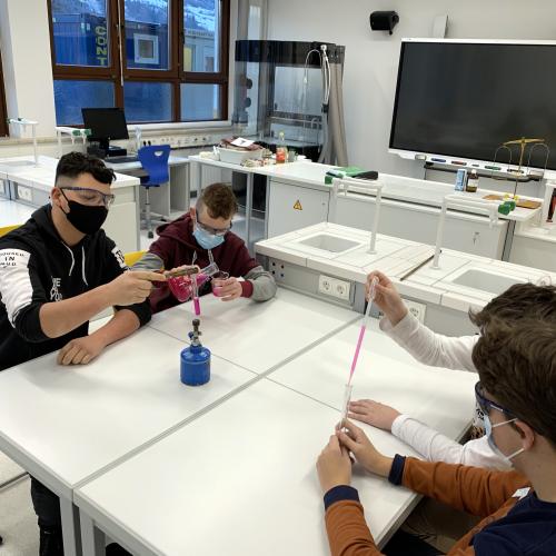 Schüler beim Experimentieren, Display im Hintergrund