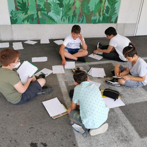 Schüler sitzen am Boden und lösen Mathematik Aufgaben