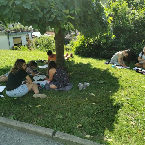 SchülerInnen liegen auf der Wiese und lösen Mathematik Aufgaben