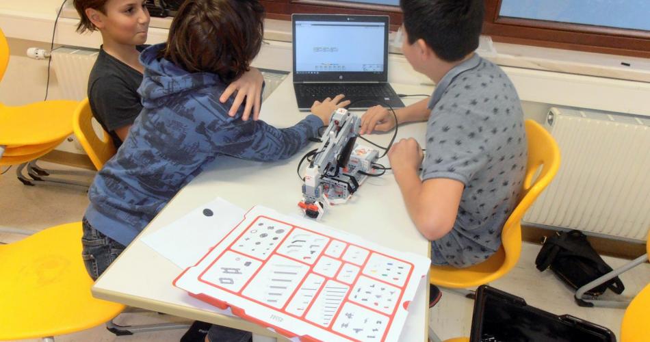 Schüler beim Programmieren von einem Lego Roboter