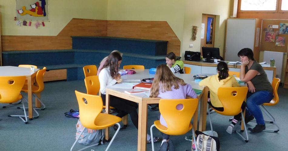 Schülerinnen und Schüler bei der gemeinsamen Erledigungen von Hausübungen in der Bibliothek