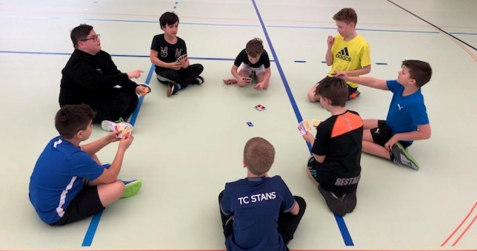 Kinder im Kreis sitzend beim gemeinsamen Spiel