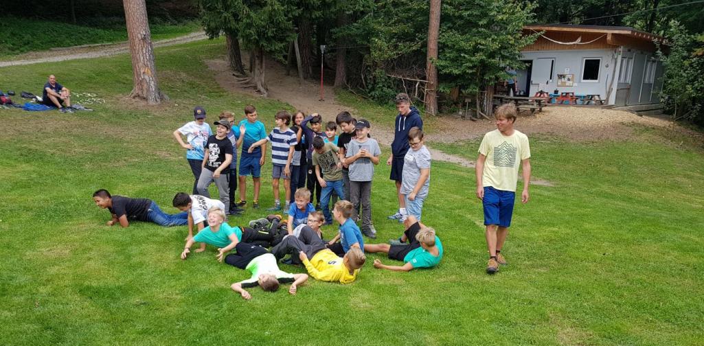 Waldtag 5 Schülergruppe beim sozialen Spiel auf Waldlichtung